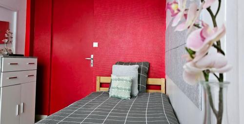 - une chambre dotée d'un lit avec un mur rouge dans l'établissement Le Canut Duviard - proche métro Croix-Rousse, à Lyon