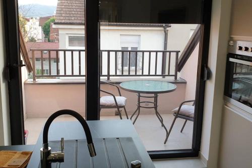 mit Blick auf einen Balkon mit einem Tisch und Stühlen in der Unterkunft R-RESIDENCY DELUXE in Banja Luka