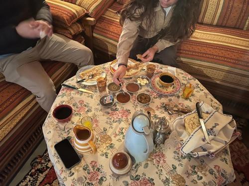 two people sitting at a table with coffee and tea at Kasbah Tigmi El Janoub in Aït Benhaddou