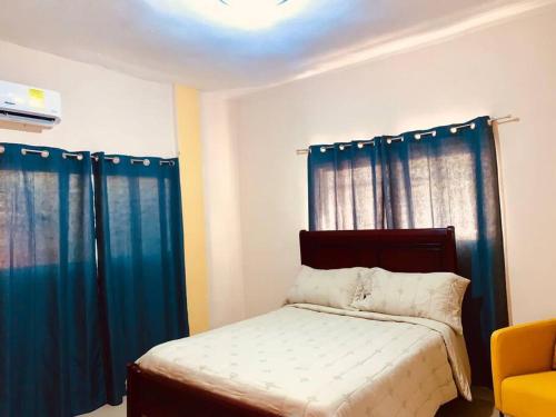 a small bedroom with blue curtains and a bed at Grande y acogedor apartamento cerca de la playa. in Azua de Compostela