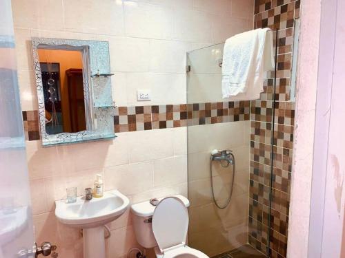 ein Badezimmer mit einem WC, einem Waschbecken und einem Spiegel in der Unterkunft Grande y acogedor apartamento cerca de la playa. in Azua de Compostela