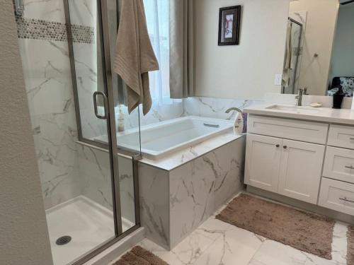 ein Badezimmer mit Dusche, Badewanne und Waschbecken in der Unterkunft Brand New South Sacramento Home in Sacramento
