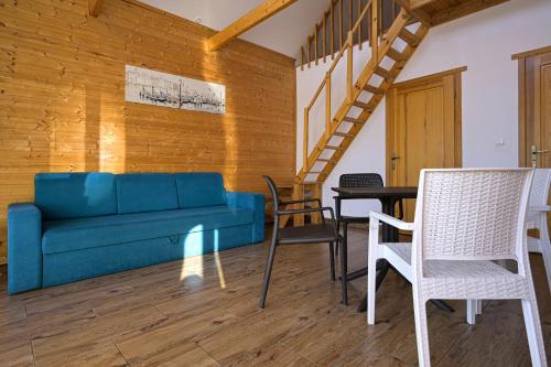 a living room with a blue couch and chairs at Domki Mewa in Jantar