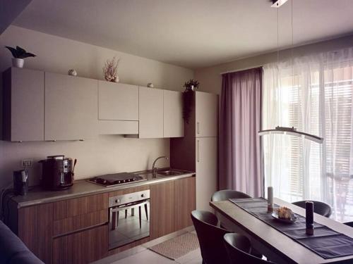 una cocina con armarios blancos y una mesa con comedor. en OceanDream Beach House Apartment en Sal Rei