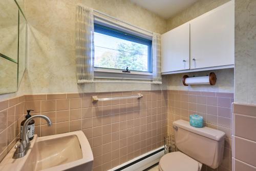 baño con aseo y lavabo y ventana en Pet-Friendly Marblehead Home Near Preston Beach!, en Marblehead