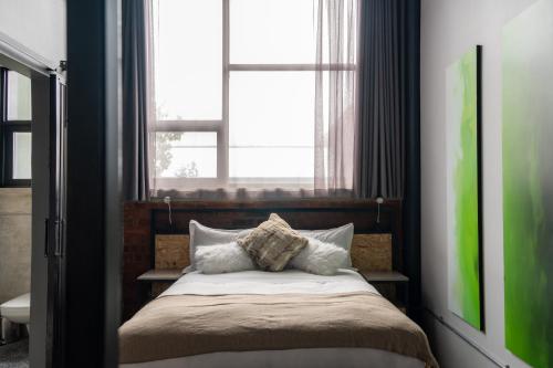 a bedroom with a bed with a large window at Lilian Lofts Hotel & Spa in Johannesburg