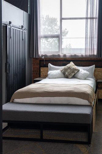 a bed in a bedroom with a large window at Lilian Lofts Hotel & Spa in Johannesburg