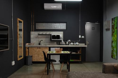 a kitchen with a table and a refrigerator at Lilian Lofts Hotel & Spa in Johannesburg