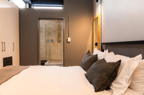 a bedroom with a bed with pillows and a shower at Lilian Lofts Hotel & Spa in Johannesburg