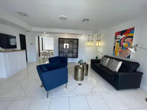 a living room with a couch and two blue chairs at Stylish Home close to everything in Hollywood