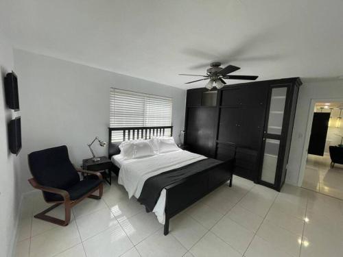 a bedroom with a bed and a chair and a ceiling fan at Stylish Home close to everything in Hollywood