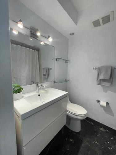 a white bathroom with a sink and a toilet at Stylish Home close to everything in Hollywood