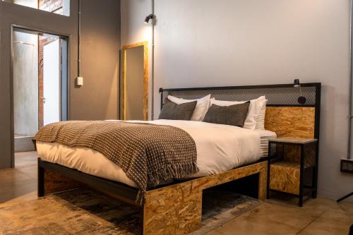 a bedroom with a large bed with a wooden headboard at Lilian Lofts Hotel & Spa in Johannesburg