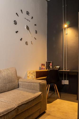 a living room with a couch and a clock on the wall at Lilian Lofts Hotel & Spa in Johannesburg