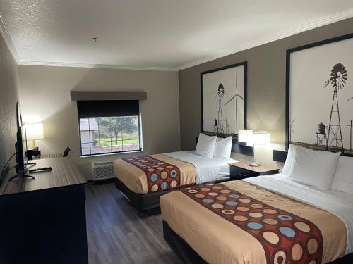 a hotel room with two beds and a window at Super 8 by Wyndham San Antonio/Alamodome Area in San Antonio