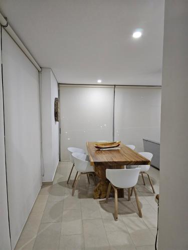 a room with a wooden table and white chairs at Yellow beach & rest II in Coveñas