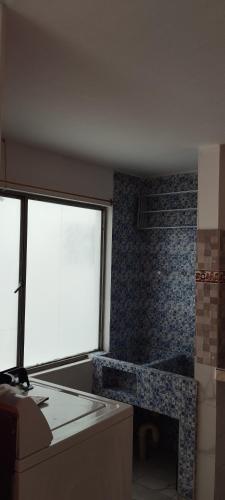 ein Wohnzimmer mit einem Kamin und einem Fenster in der Unterkunft Ipiales Puerta de Oro Alborada in Ipiales