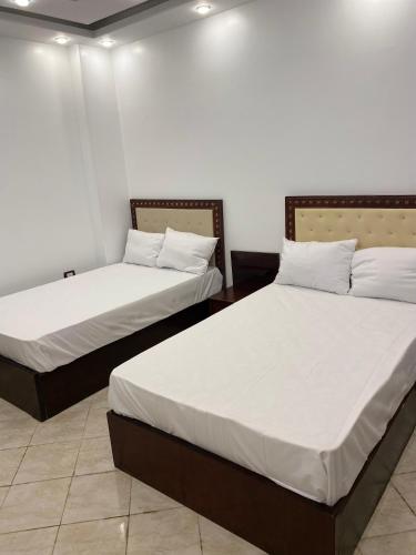 two beds sitting next to each other in a room at Enjoy pyramids Golden Hotel in Cairo