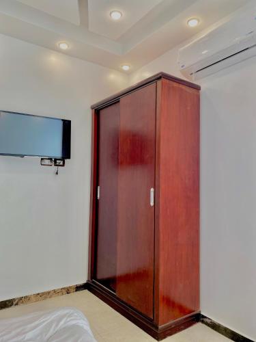 a wooden cabinet in a room with a tv at Enjoy pyramids Golden Hotel in Cairo