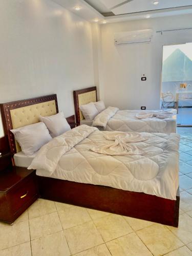 two beds sitting next to each other in a room at Enjoy pyramids Golden Hotel in Cairo