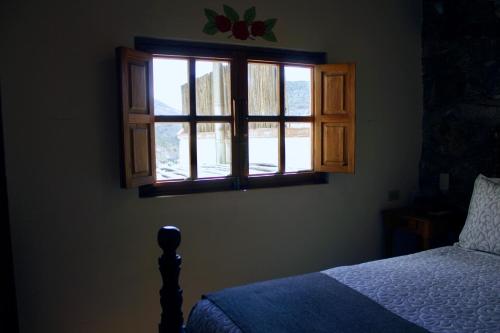 a bedroom with a bed and a window at Hotel Amor y Paz in Real de Catorce