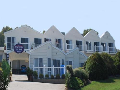 a large white house with a sign in front of it at A Great Ocean View Motel in Apollo Bay