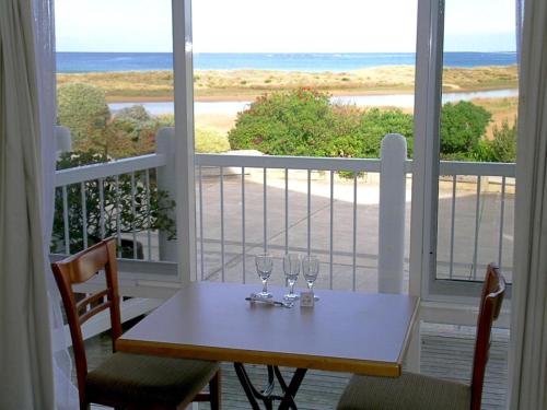 a table with two wine glasses on a balcony at A Great Ocean View Motel in Apollo Bay