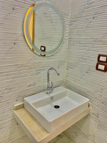 a white sink in a bathroom with a mirror at Enjoy pyramids Golden Hotel in Cairo