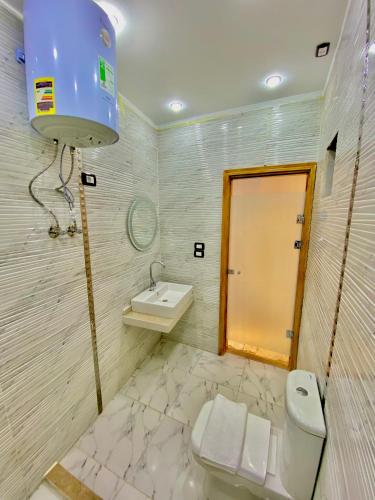 a bathroom with a toilet and a sink at Enjoy pyramids Golden Hotel in Cairo