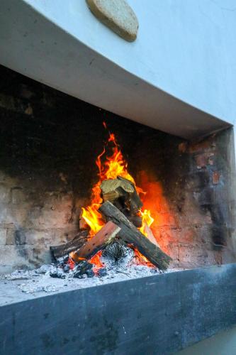 a fire inside of a brick oven with flames at Barefoot Addo Elephant Lodge in Addo