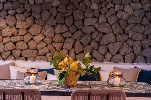 a table with a basket of fruit and candles on it at Costa Del Capitano Seaside Villas in Ischia