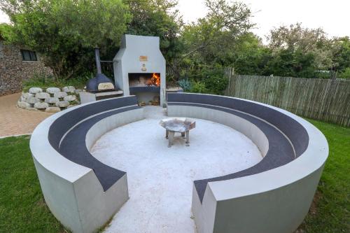 a backyard with a fire pit and a fireplace at Barefoot Addo Elephant Lodge in Addo
