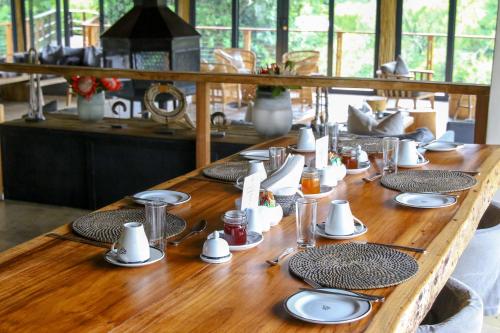 a long wooden table with plates and dishes on it at Barefoot Addo Elephant Lodge in Addo