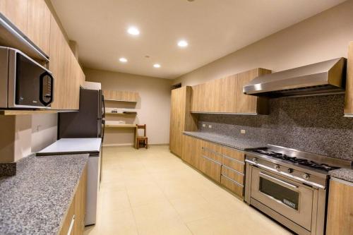 a kitchen with granite counter tops and stainless steel appliances at Casa Luz De Luna-MANCORA in Máncora