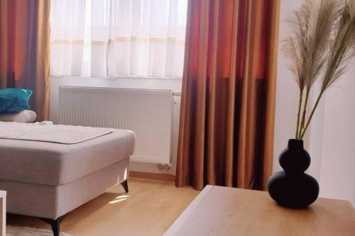 a bedroom with a bed and a vase on a table at R-RESIDENCe in Banja Luka