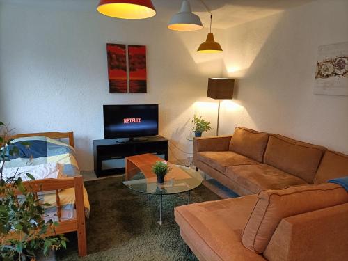 - un salon avec un canapé et une télévision dans l'établissement Three bedroom apartment in Heerlen, à Heerlen