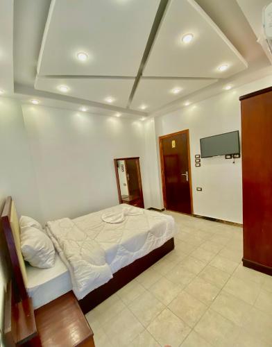 a bedroom with a bed and a flat screen tv at Enjoy pyramids Golden Hotel in Cairo
