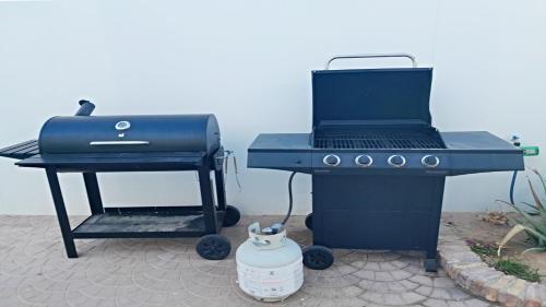 a charcoal grill and a bbq smoker with a kettle at Brand New Beautiful House La Brisas by Kivoya in Playa Encanto