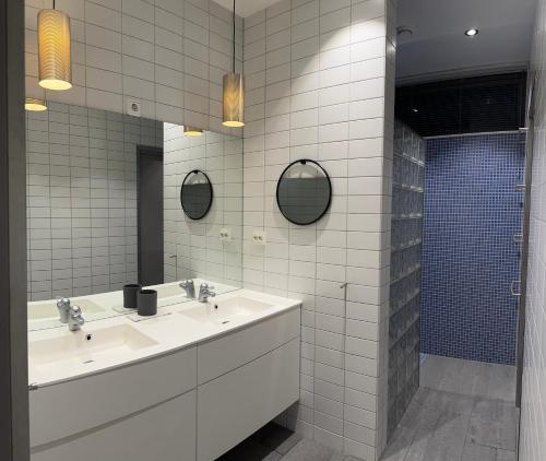 a bathroom with two sinks and two mirrors at North Apartment City house. in Tromsø