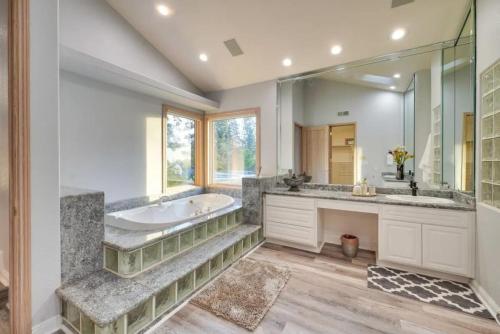 a bathroom with a tub and a large mirror at Mansion, Pool, Game Room in Pollock Pines