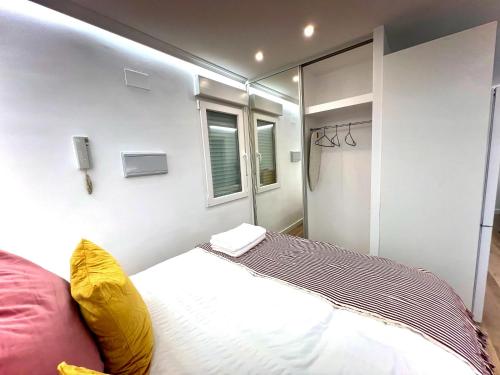 um pequeno quarto com uma cama e uma janela em APARTMENT IN THE HEART OF MADRID-PISO EN MALASAÑA em Madri