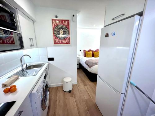 a small kitchen with a sink and a refrigerator at APARTMENT IN THE HEART OF MADRID-PISO EN MALASAÑA in Madrid