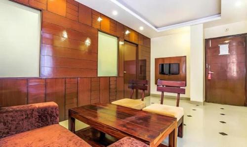 sala de estar con mesa de madera y sillas en Hotel Wonderland Inn, en Jaipur