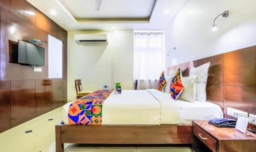 Schlafzimmer mit einem Bett, einem Schreibtisch und einem TV in der Unterkunft Hotel Wonderland Inn in Jaipur