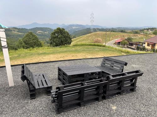 two benches sitting on the ground next to a hill at ATETA Tiny House 