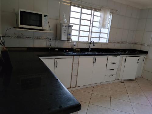 eine Küche mit einer Spüle und einer Mikrowelle in der Unterkunft Brasilia Vale Park Way in Brasilia