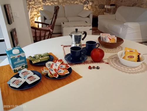 einen Tisch mit Teller mit Lebensmitteln auf einem Tisch in der Unterkunft Valdastico Casetta in sasso con giardino in Pedemonte