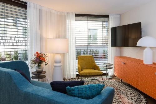 a living room with a blue couch and a chair at ANTON Dolomites Hideaway in Brunico