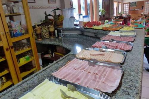 a counter with many plates of food on it at Pousada Alpes da Serra Campos do Jordão in Campos do Jordão