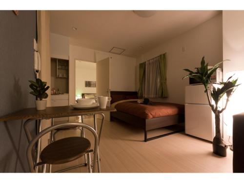 a living room with a bed and a table and chairs at Mini Hotel Shinjuku Front - Vacation STAY 89794v in Tokyo